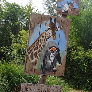 Painted signs pointing towards giraffe and guenon indoor housing and mixed aviary, 2019-08-11