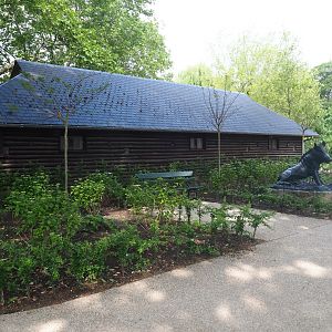 Backside of former bovine barn with boar statue and gardens, 2022-05-26