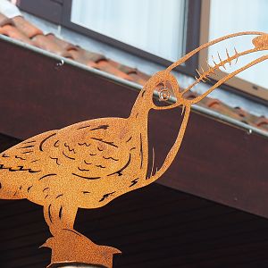 Tucan metal cut-out artwork on top of map, 2022-08-28