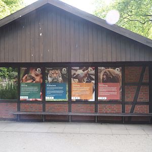 Coati house with signage about the zoo's mission and indoor viewing window, 2025-05-22