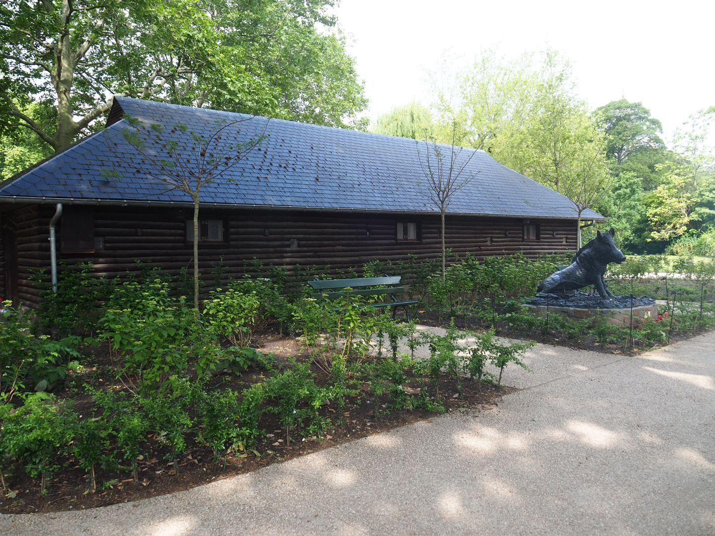 Backside of former bovine barn with boar statue and gardens, 2022-05-26