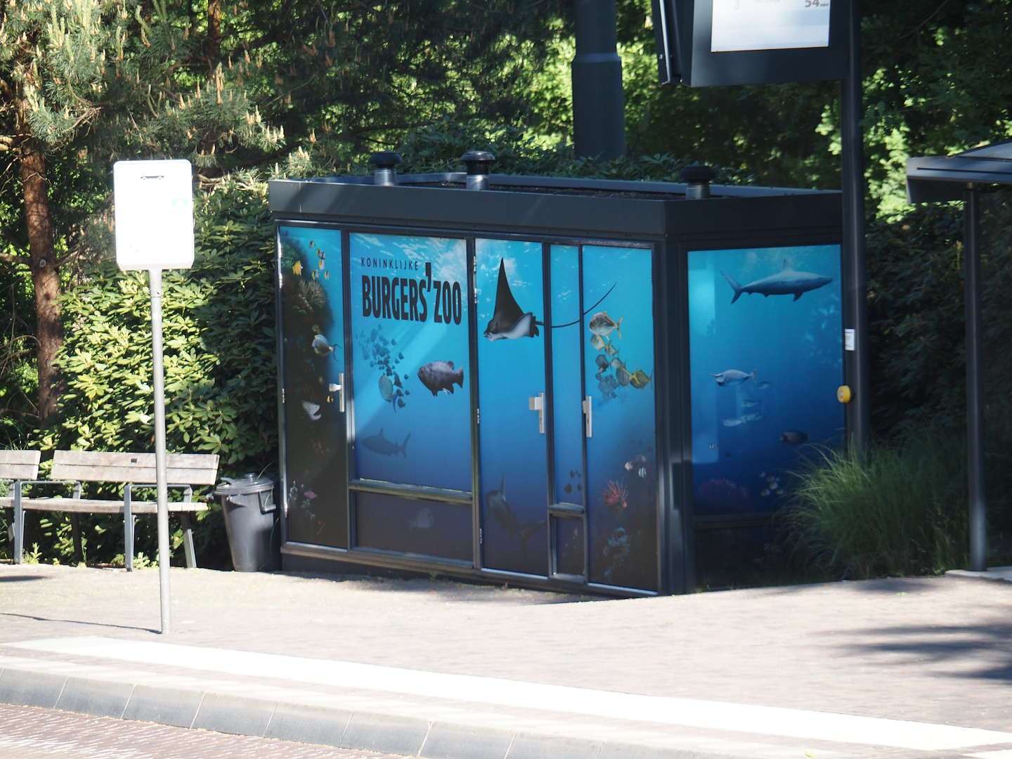 Cabin with Burgers' Ocean decals next to bus stop, 2025-05-17