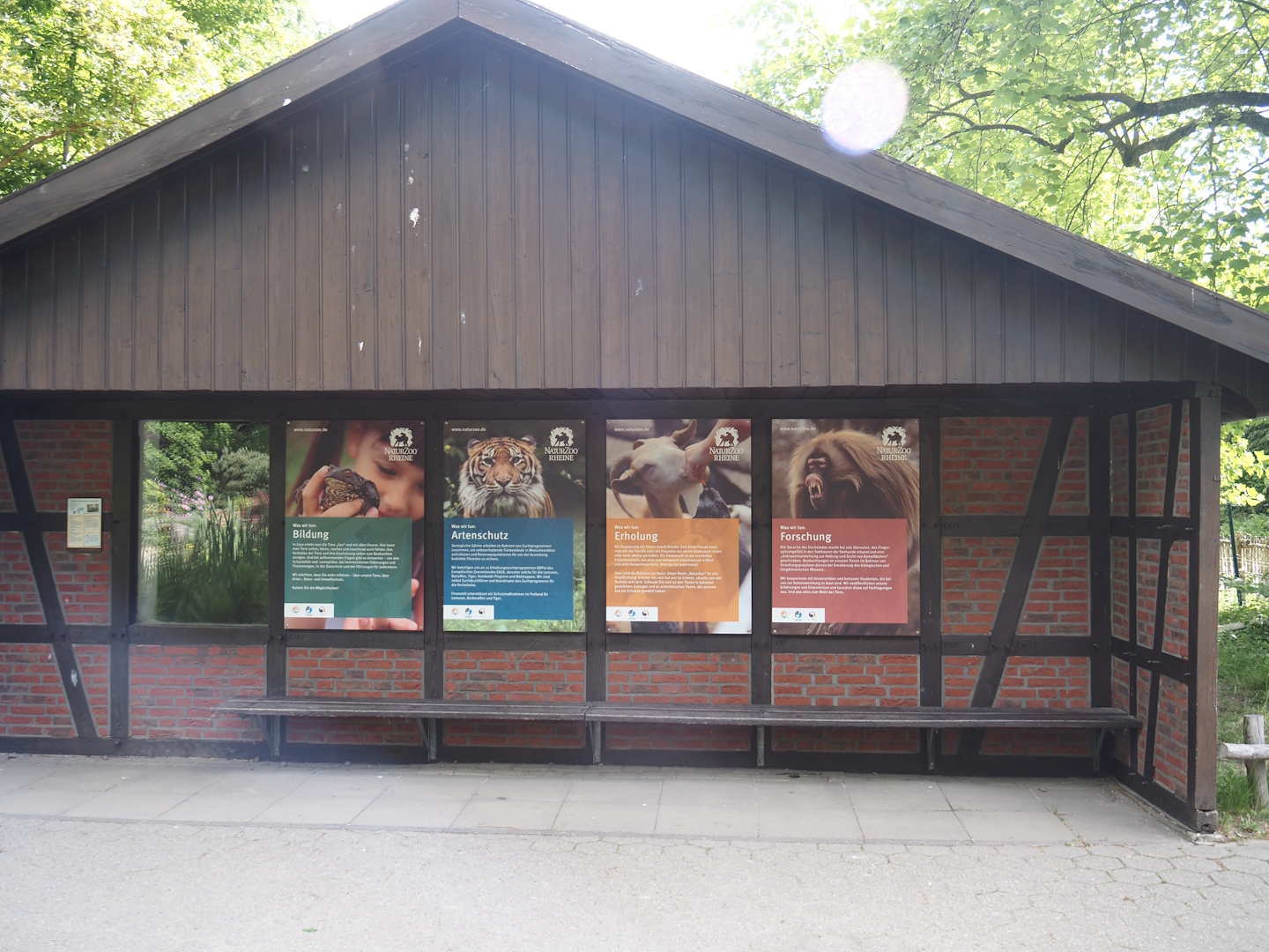 Coati house with signage about the zoo's mission and indoor viewing window, 2025-05-22