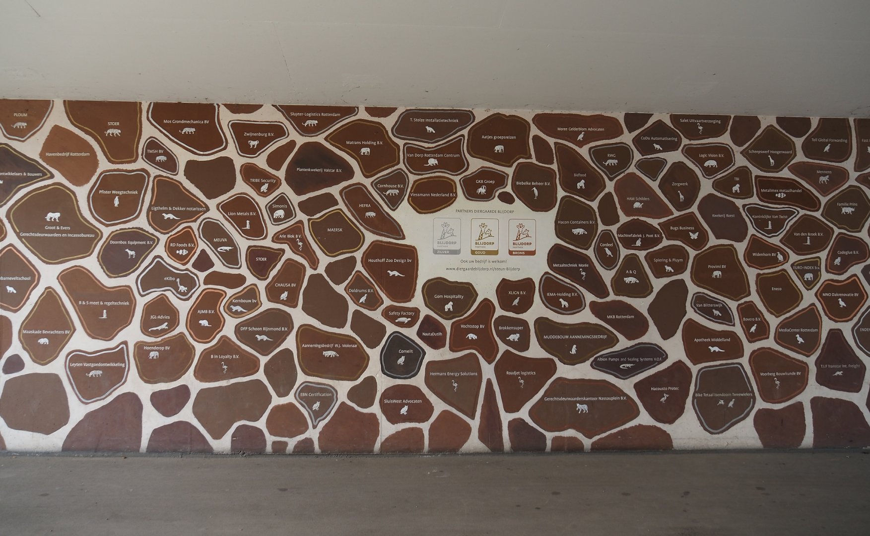 Corporate sponsors signage in tunnel under railroad between the two parts of the zoo, 2024-06-30