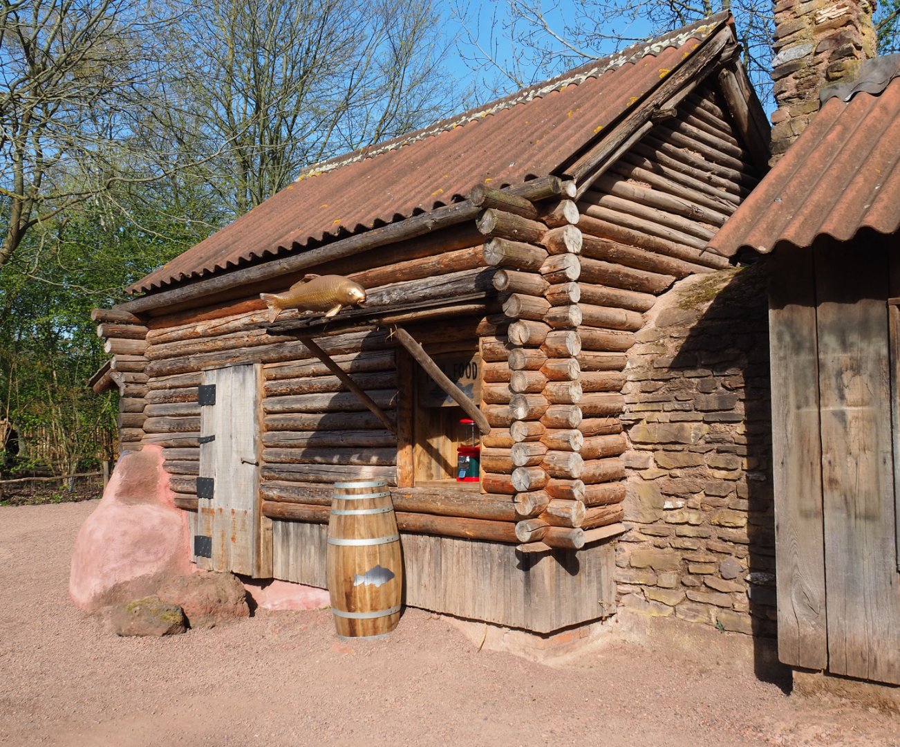 Former wombat and pademelon exhibit, now removed, and fish food dispenser with theming placed in former window, 2022-04-12