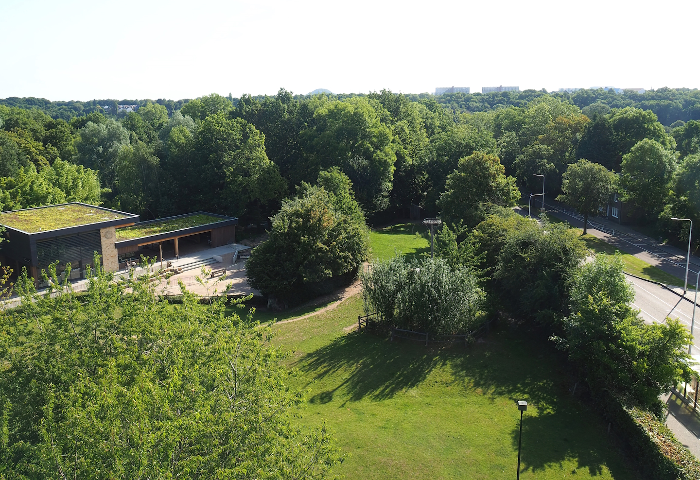 New entrance building and Lakenvelder cattle paddock seen from viewing tower next to parking lot, 2023-07-18