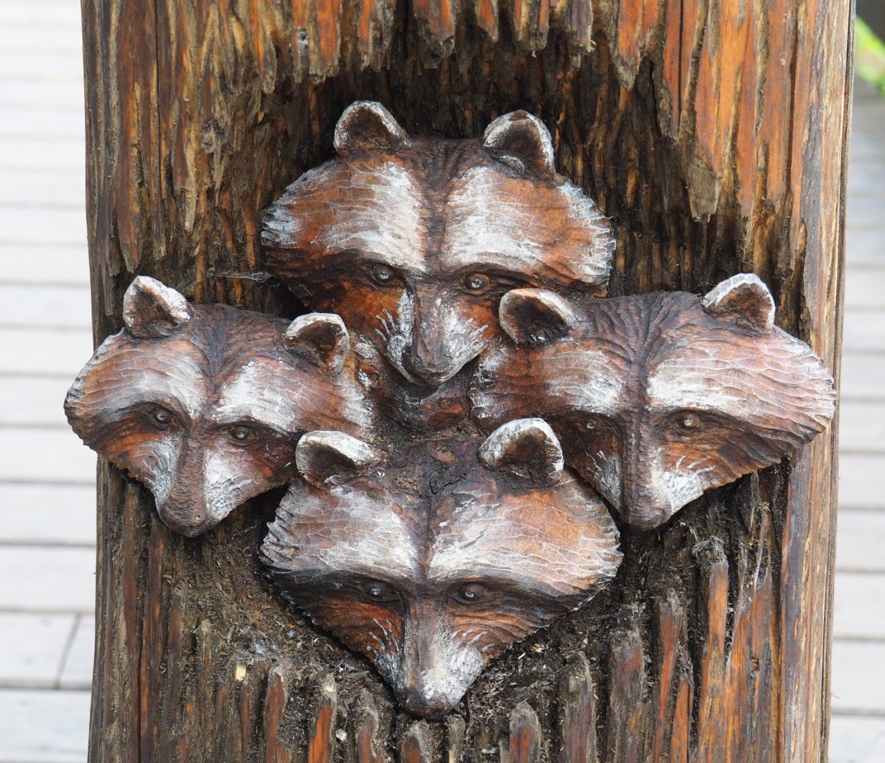 Raccoon heads wood carving near the raccoon exhibit, 2021-09-02