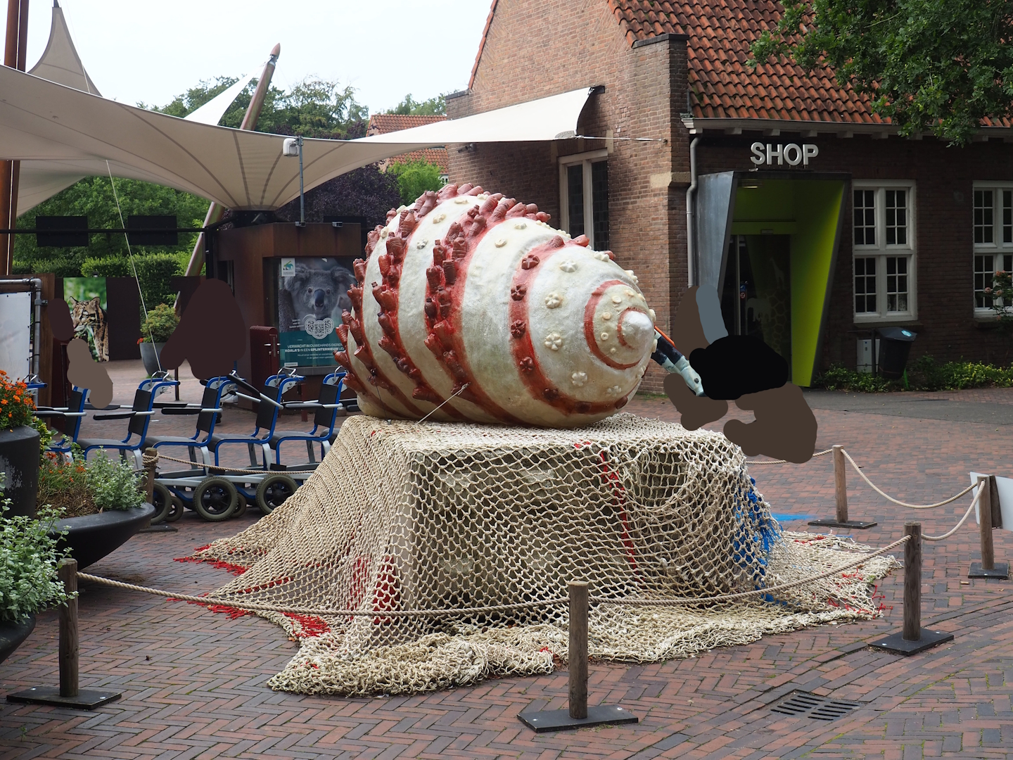 Recycled materials artwork exhibition - Hermit crab made from plastic and fishing nets, Ticket checkpoint and shop in background, 2023-08-17