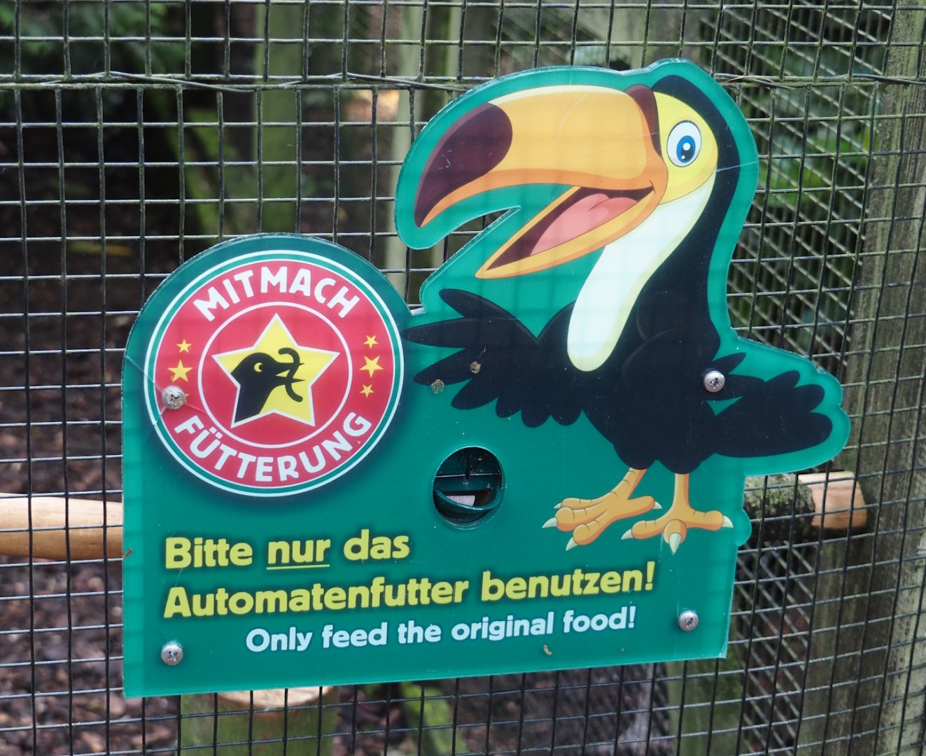 Sign indicating aviaries with birds that are allowed to bed with pellets from vending machine, 2024-05-23