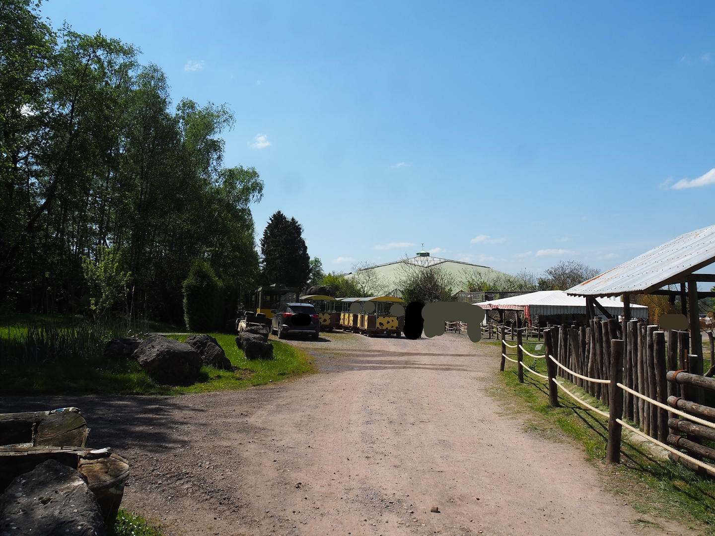 View from Aldabra giant tortoise exhibit to safari train station and tropical building, 2023-05-19